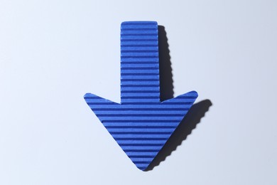 Photo of One blue paper arrow on white background, top view