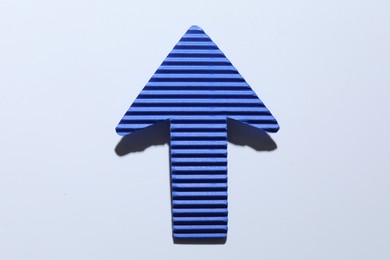 Photo of One blue paper arrow on white background, top view