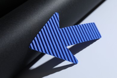 Photo of One blue paper arrow on color background, closeup