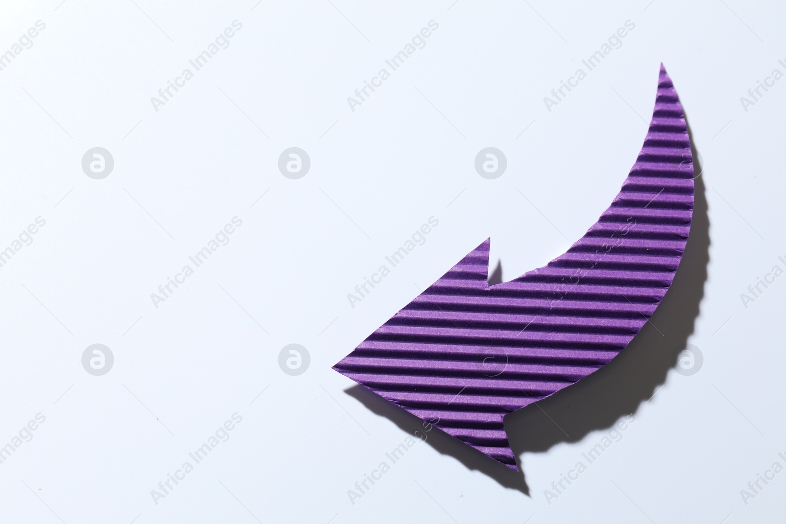 Photo of One purple paper arrow on white background, top view. Space for text