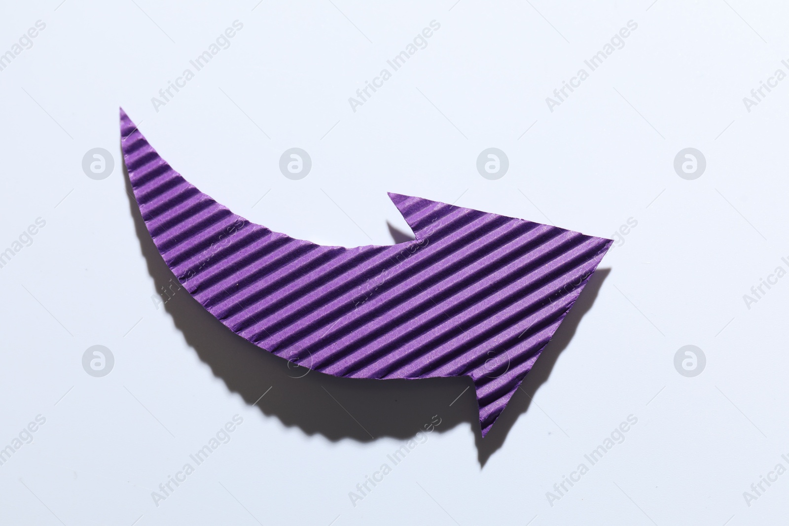 Photo of One purple paper arrow on white background, top view