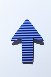 Photo of One blue paper arrow on white background, top view