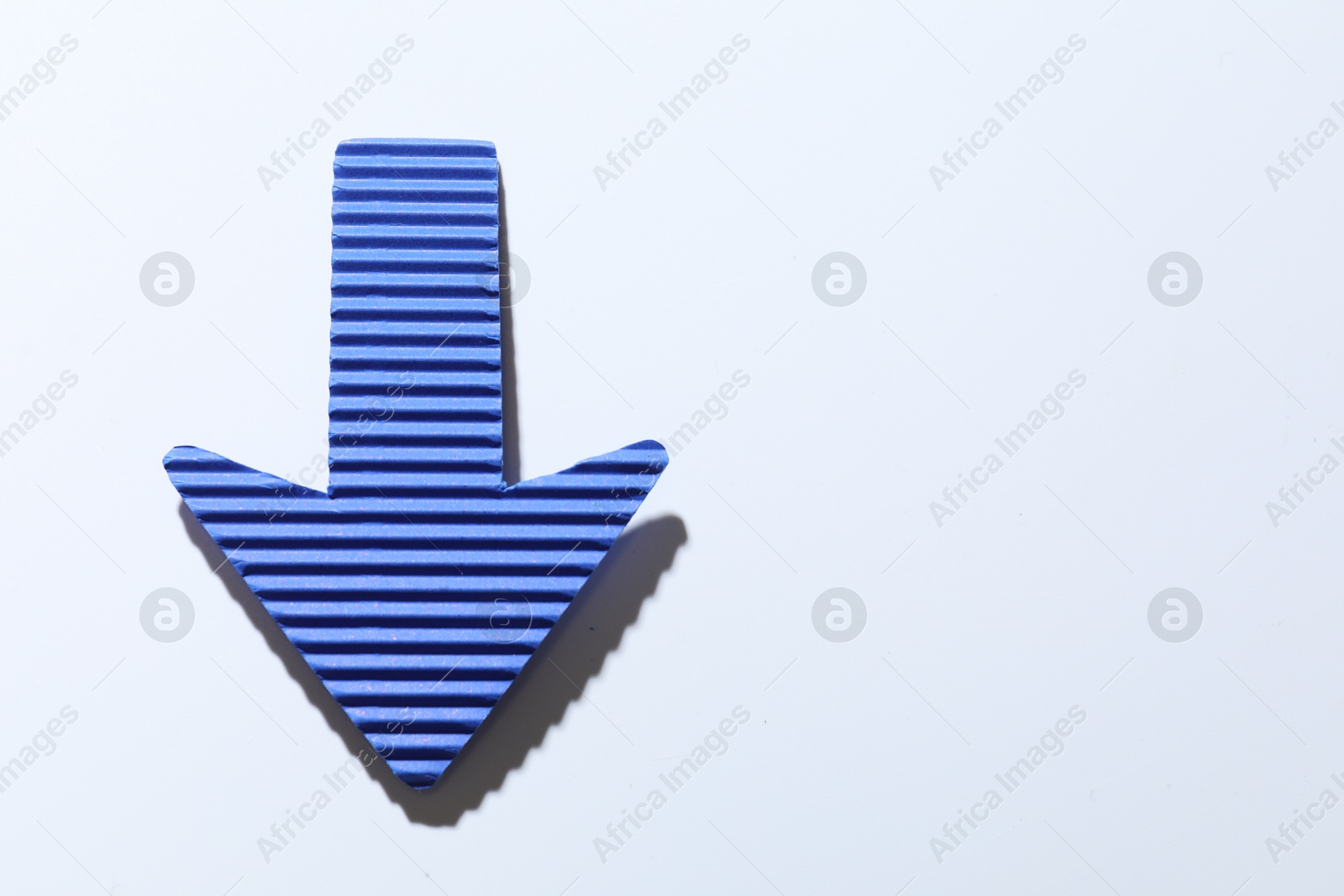 Photo of One blue paper arrow on white background, top view. Space for text