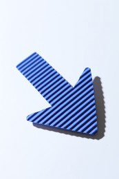 Photo of One blue paper arrow on white background, closeup