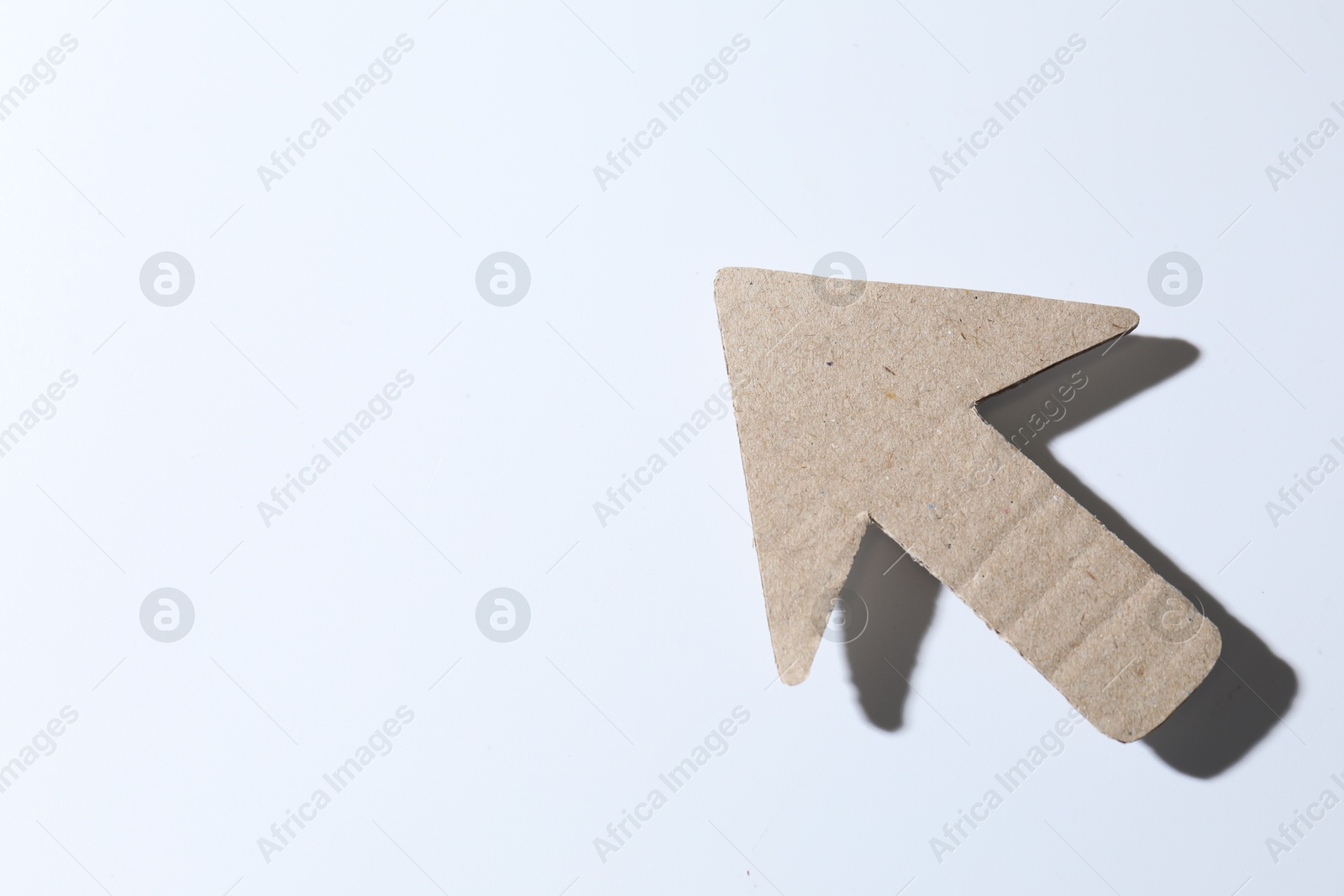 Photo of One kraft paper arrow on white background, top view. Space for text