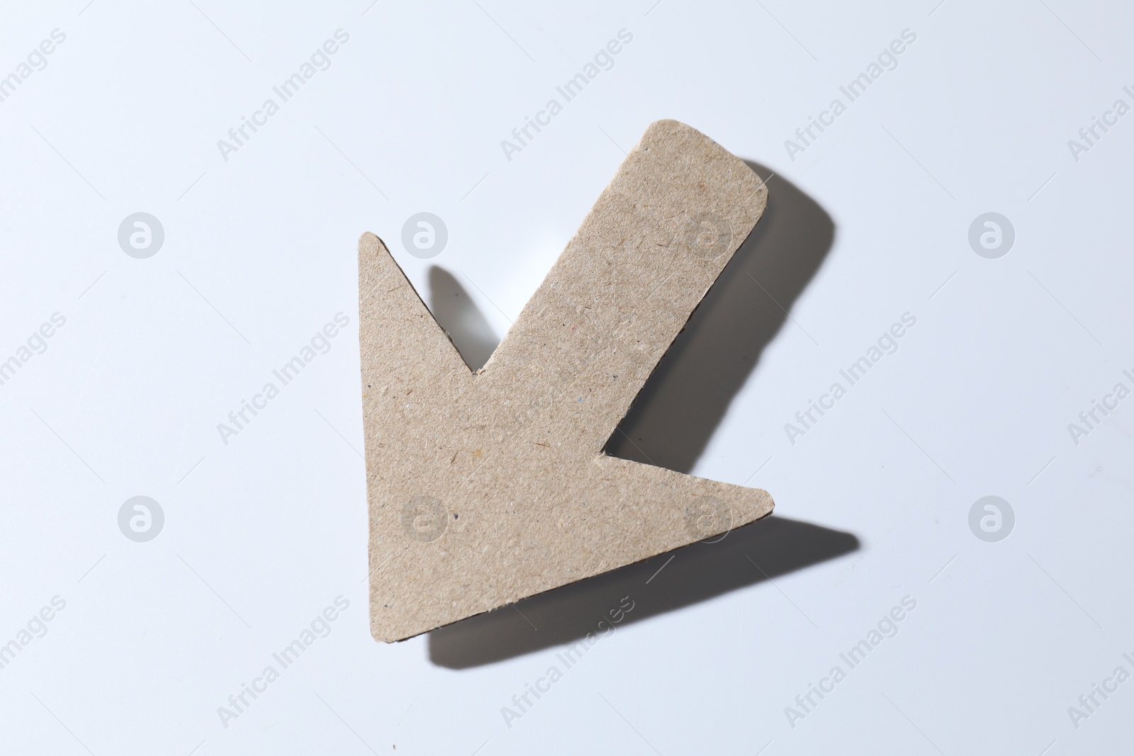 Photo of One kraft paper arrow on white background, top view