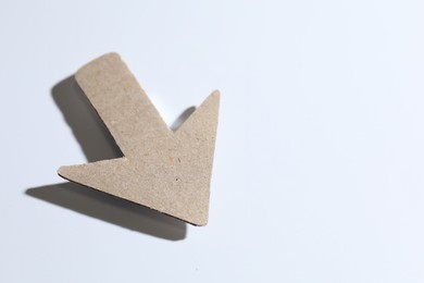 Photo of One kraft paper arrow on white background, closeup. Space for text