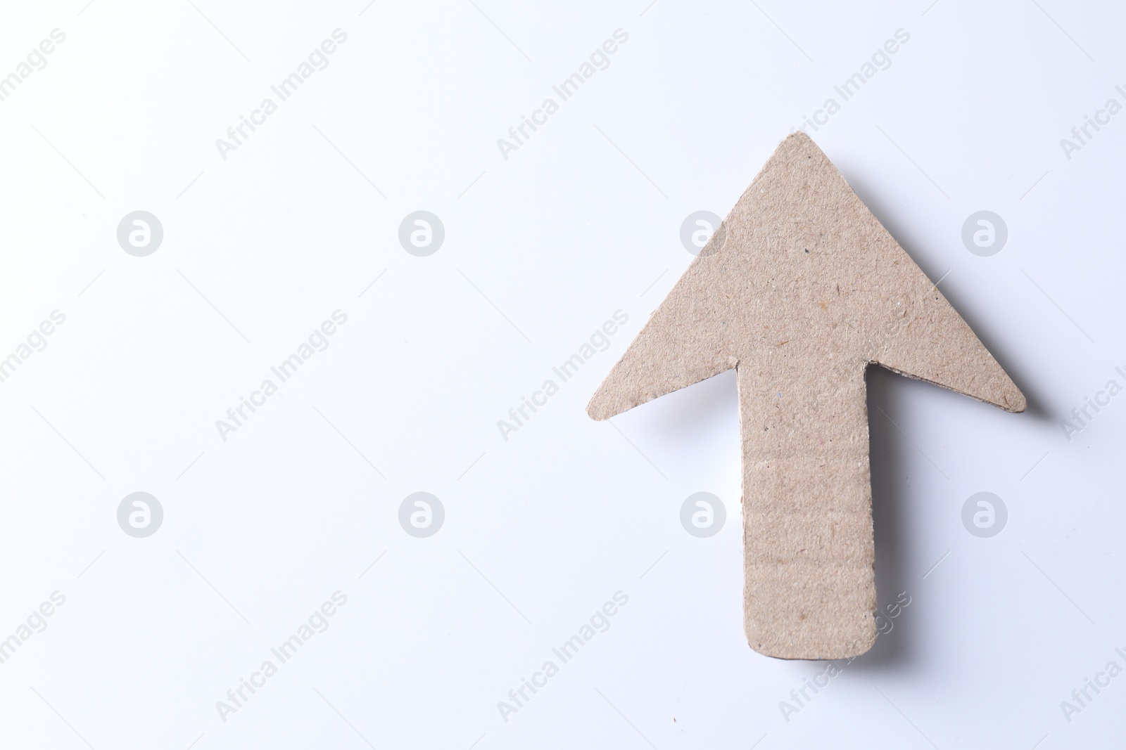 Photo of One kraft paper arrow on white background, top view. Space for text