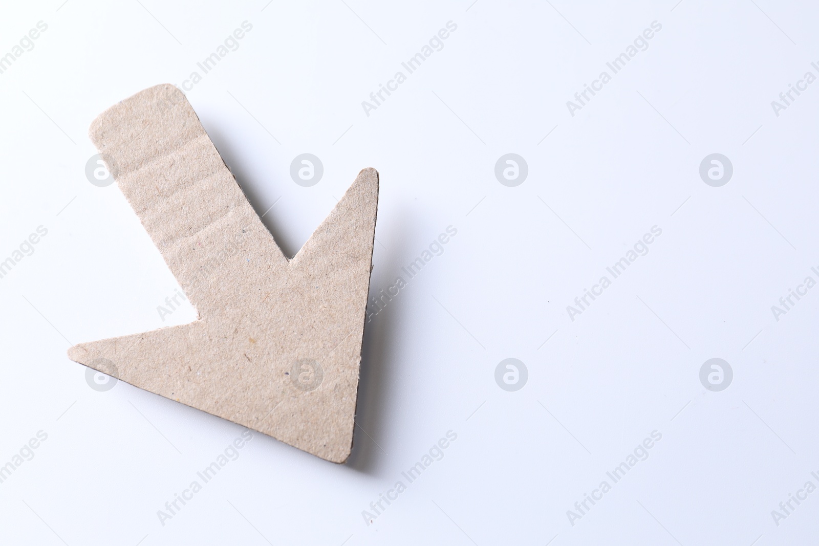 Photo of One kraft paper arrow on white background, top view. Space for text