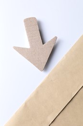 Photo of One kraft paper arrow on color background, top view