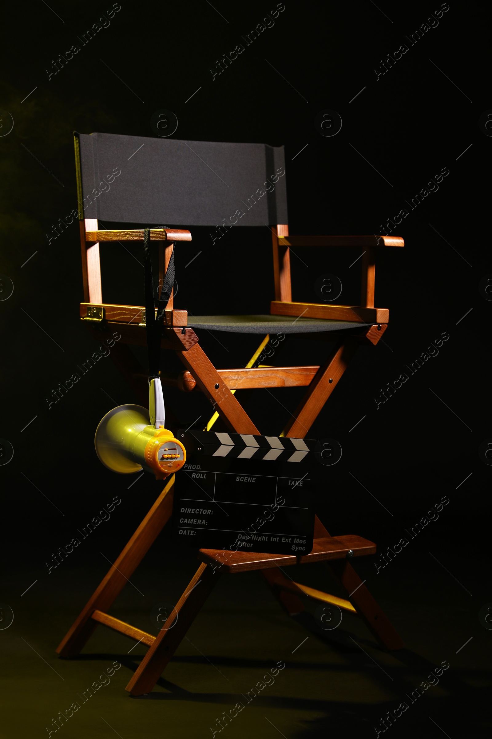 Photo of Director's chair with clapperboard and megaphone on black background