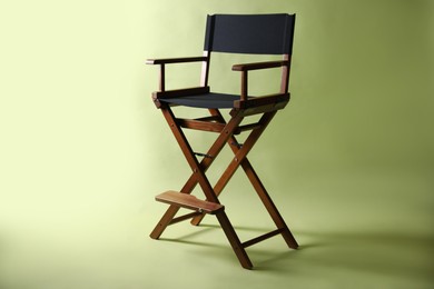 Photo of One empty director's chair on pale olive background