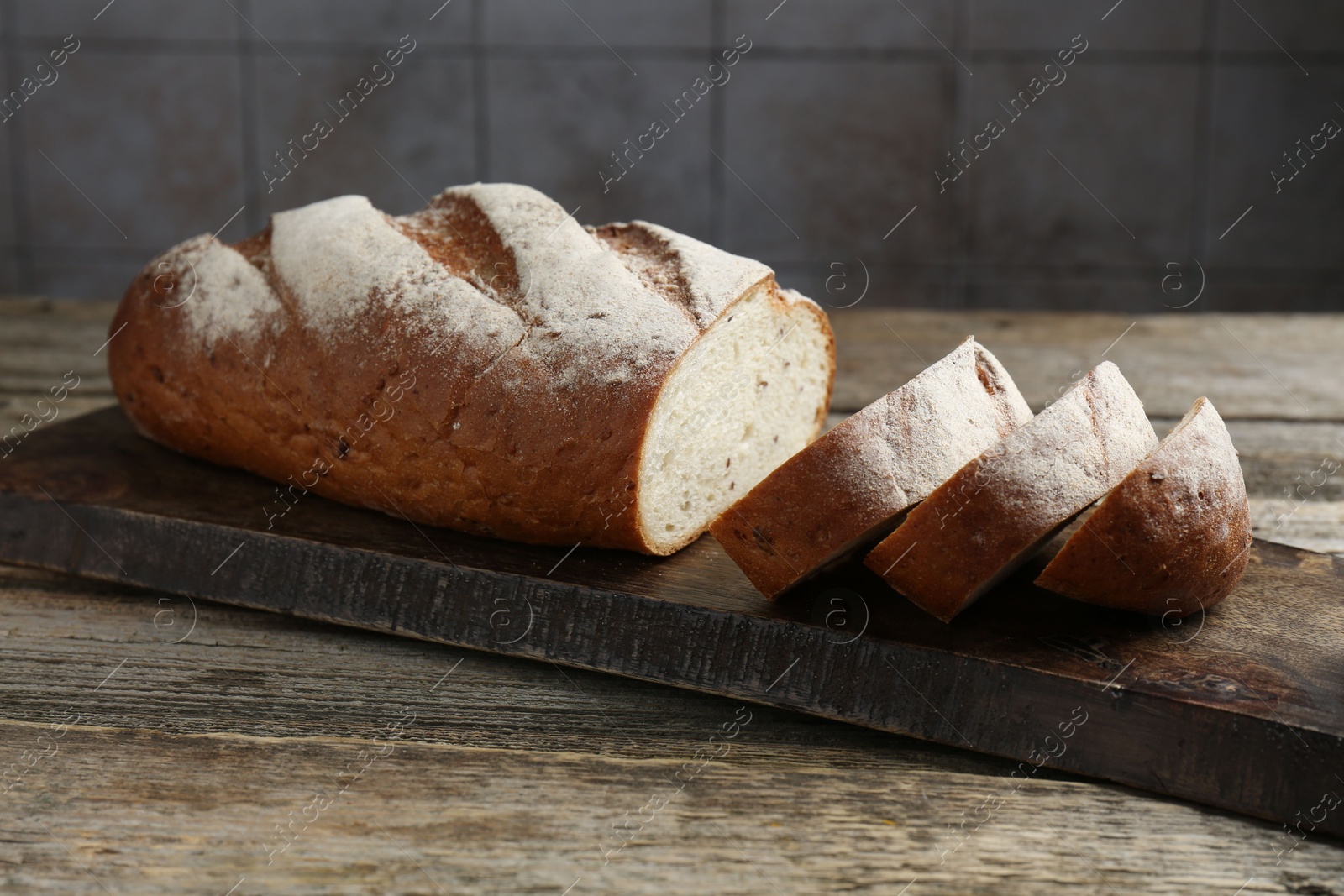 Photo of Cutting board with fresh bread on wooden table, closeup