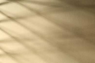 Photo of Light and shadows falling on beige background