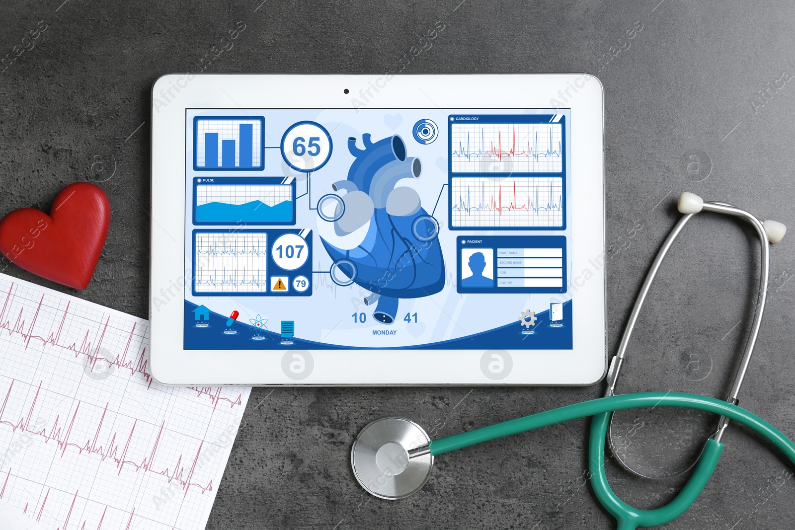 Image of Cardiology. Doctor's workplace with stethoscope and tablet computer on grey textured table, top view. Data on device screen