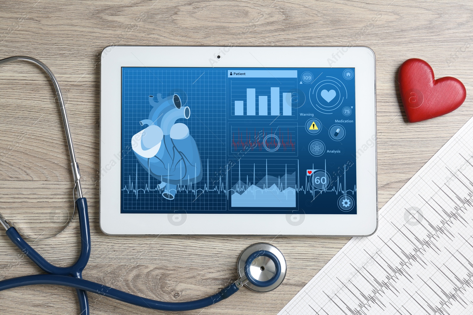 Image of Cardiology. Doctor's workplace with stethoscope and tablet computer on wooden table, top view. Data on device screen