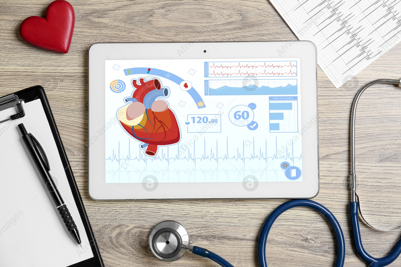 Image of Cardiology. Doctor's workplace with stethoscope and tablet computer on wooden table, top view. Data on device screen