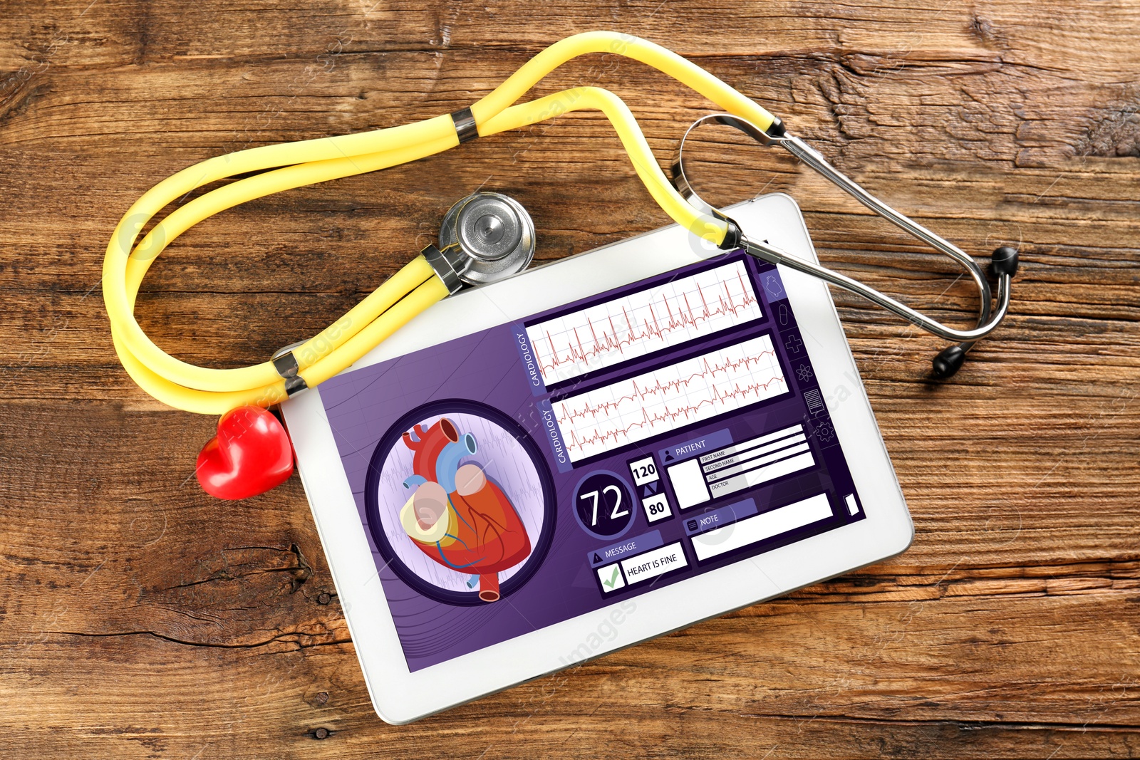 Image of Cardiology. Tablet computer with data, red heart and stethoscope on wooden table, top view