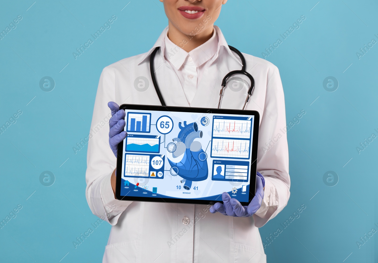 Image of Cardiology. Doctor holding tablet computer with data on screen against light blue background, closeup