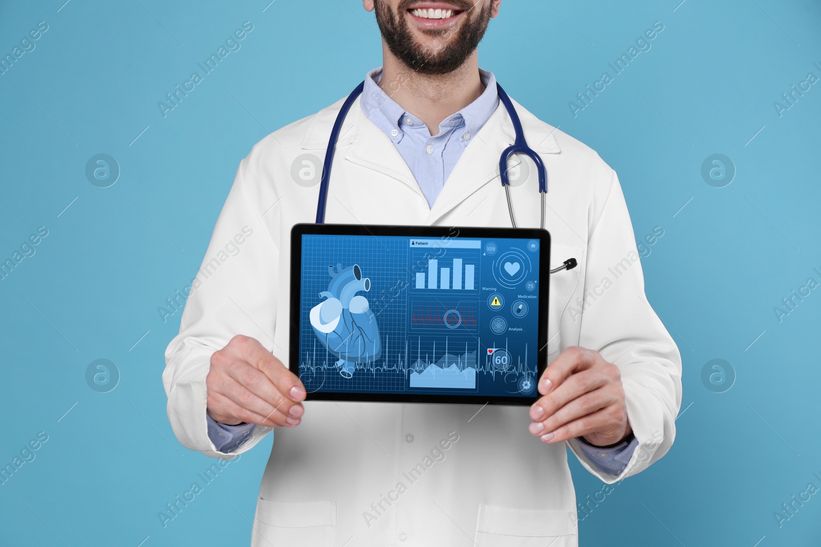 Image of Cardiology. Doctor holding tablet computer with data on screen against light blue background, closeup