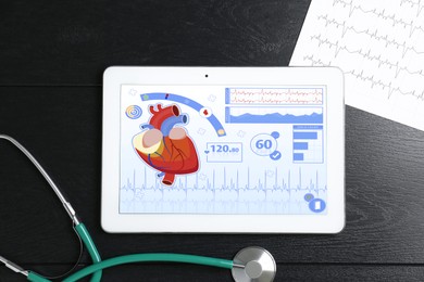 Image of Cardiology. Doctor's workplace with stethoscope and tablet computer on black wooden table, top view. Data on device screen