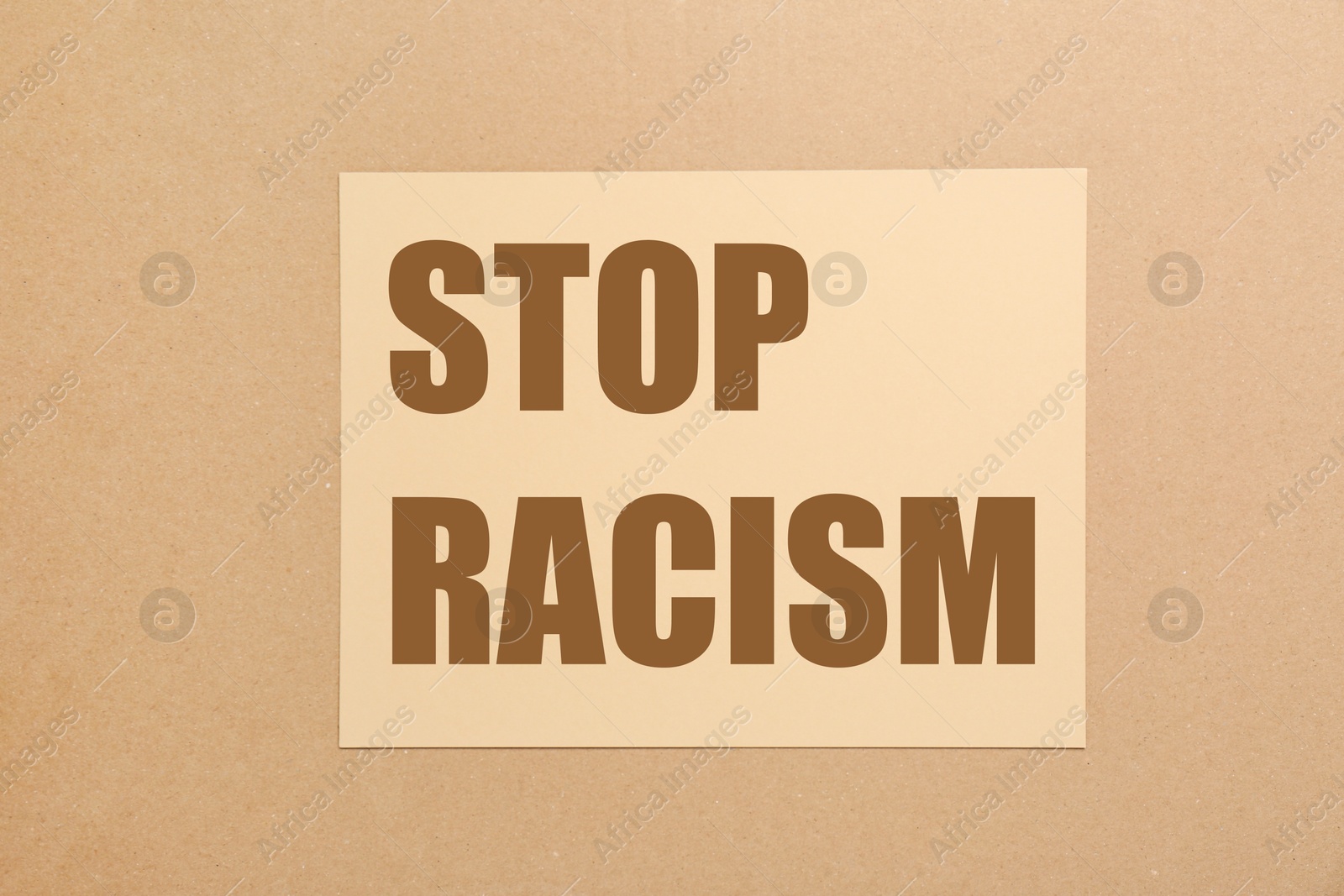 Image of Stop racism. Paper with text on beige background