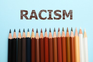 Image of Stop racism. Pencils in different colors on light blue background, top view