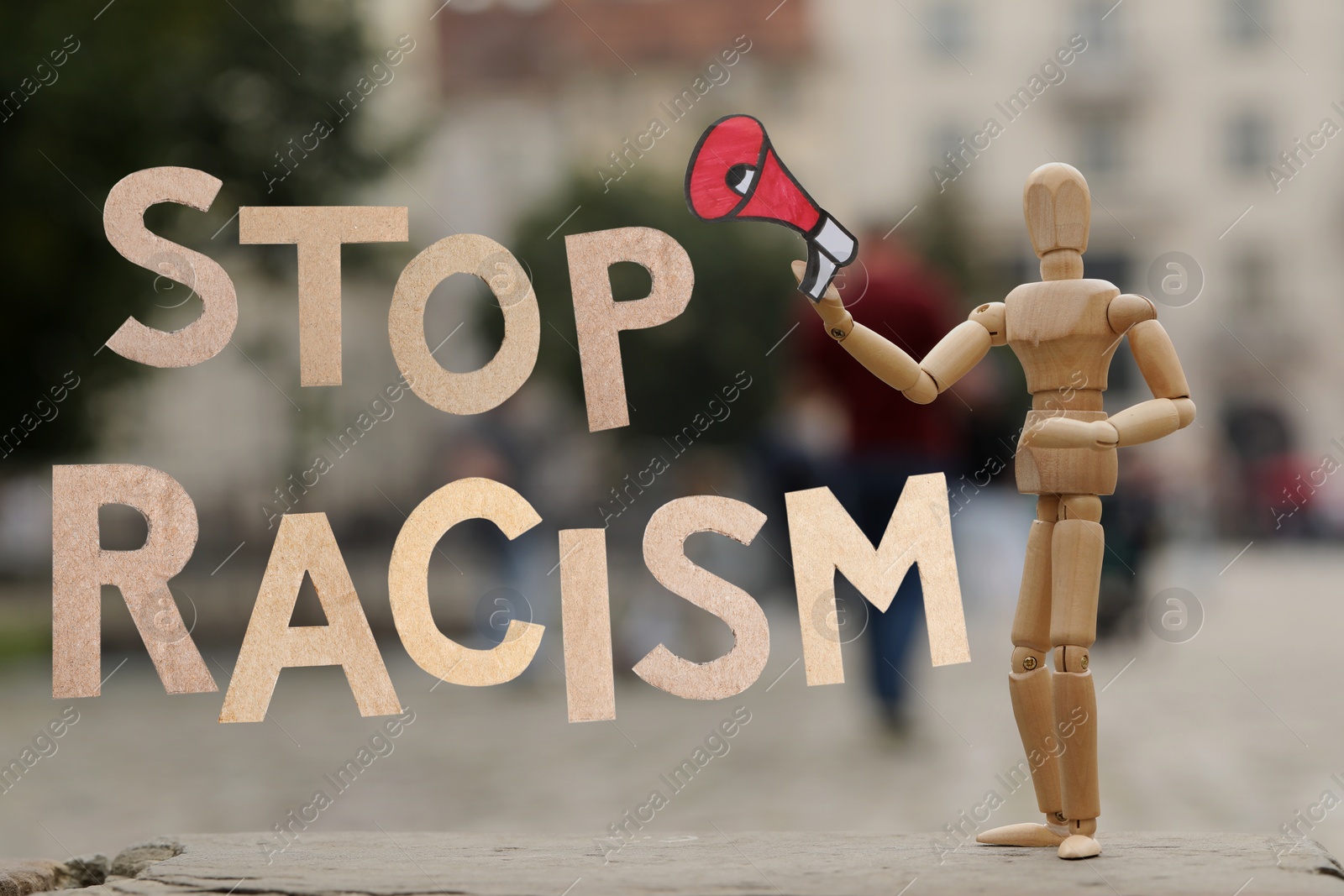 Image of Stop racism. Wooden mannequin with paper loudspeaker outdoors