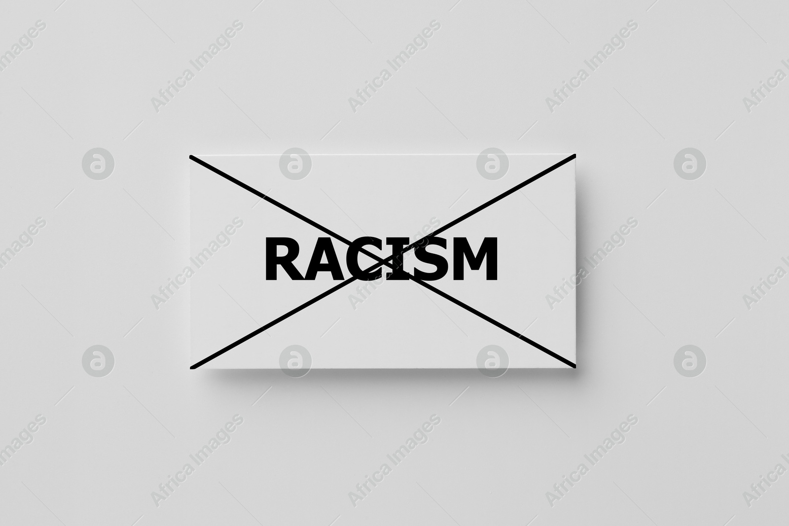 Image of Stop racism concept. Note with crossed-out word on white background, top view