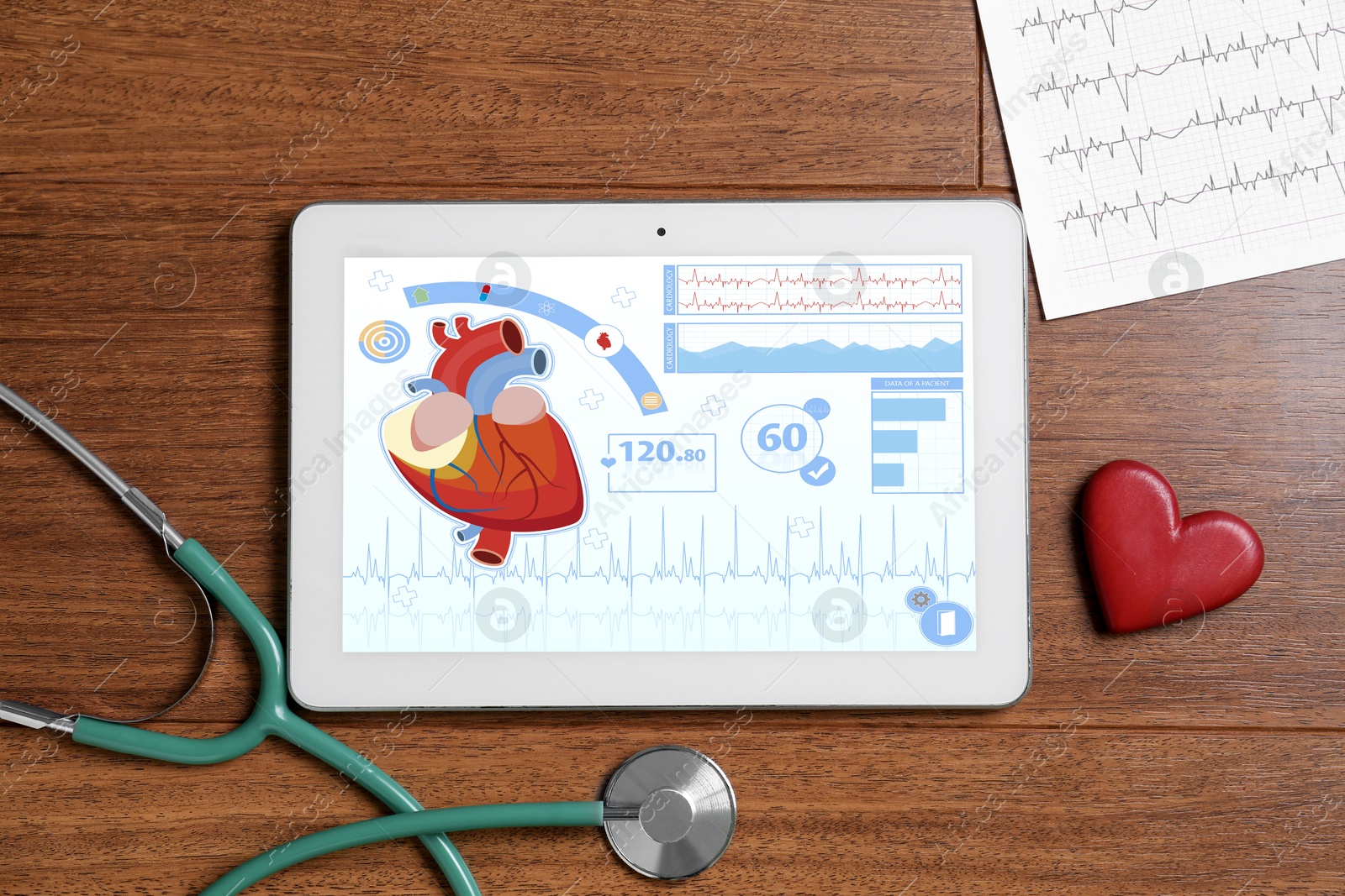 Image of Cardiology. Doctor's workplace with stethoscope and tablet computer on wooden table, top view. Data on device screen