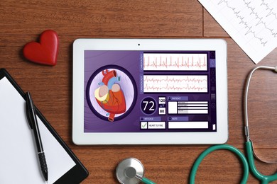 Image of Cardiology. Doctor's workplace with stethoscope and tablet computer on wooden table, top view. Data on device screen