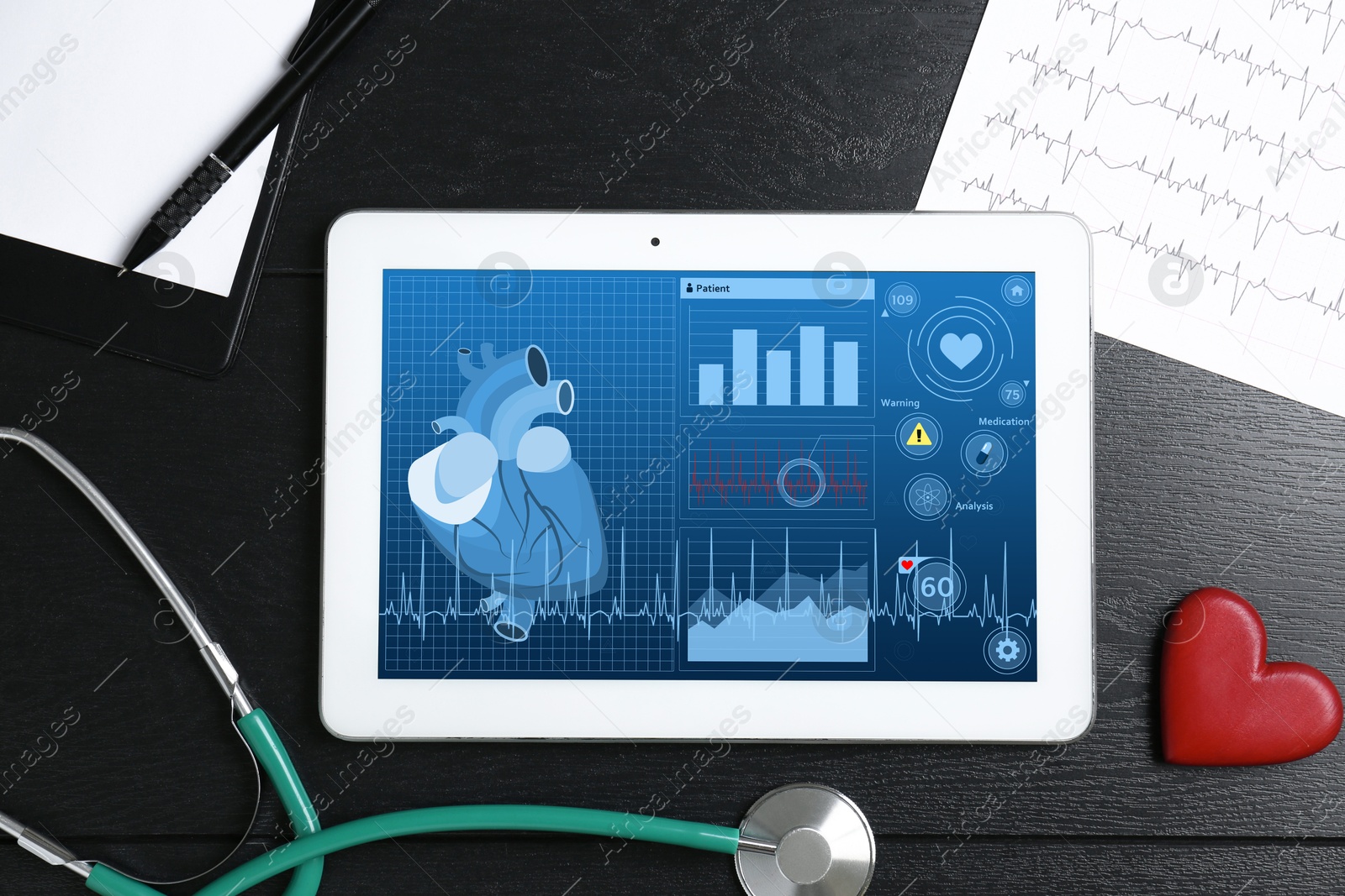 Image of Cardiology. Doctor's workplace with stethoscope and tablet computer on black wooden table, top view. Data on device screen