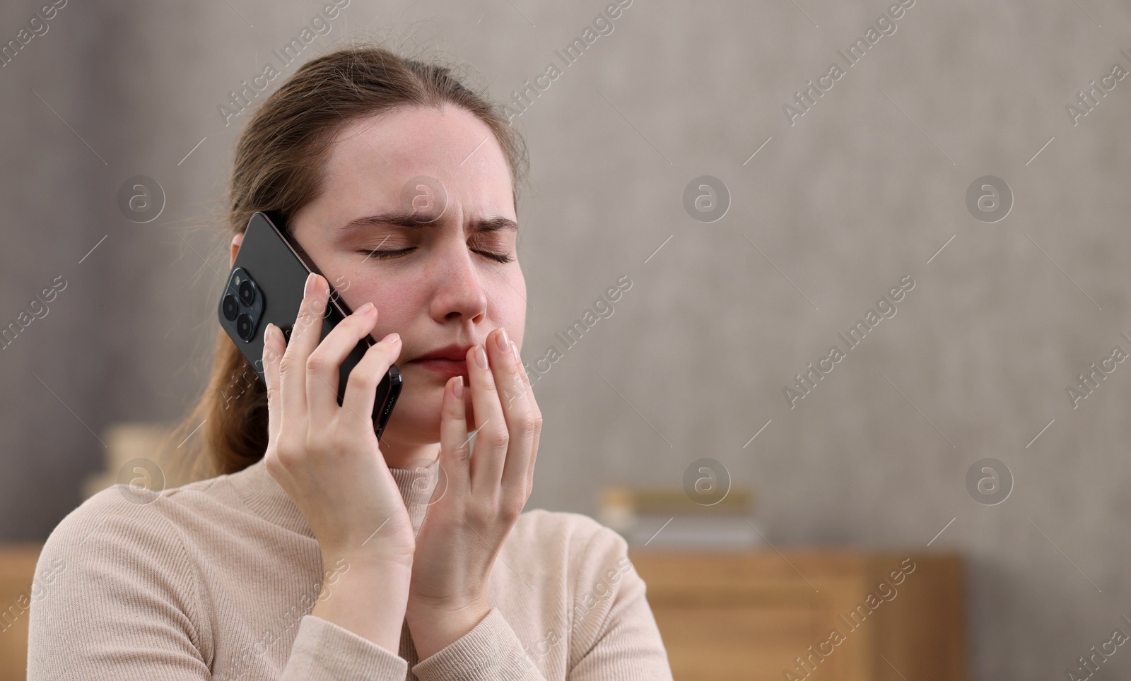 Photo of Stressed woman calling hotline for mental health help at home. Space for text