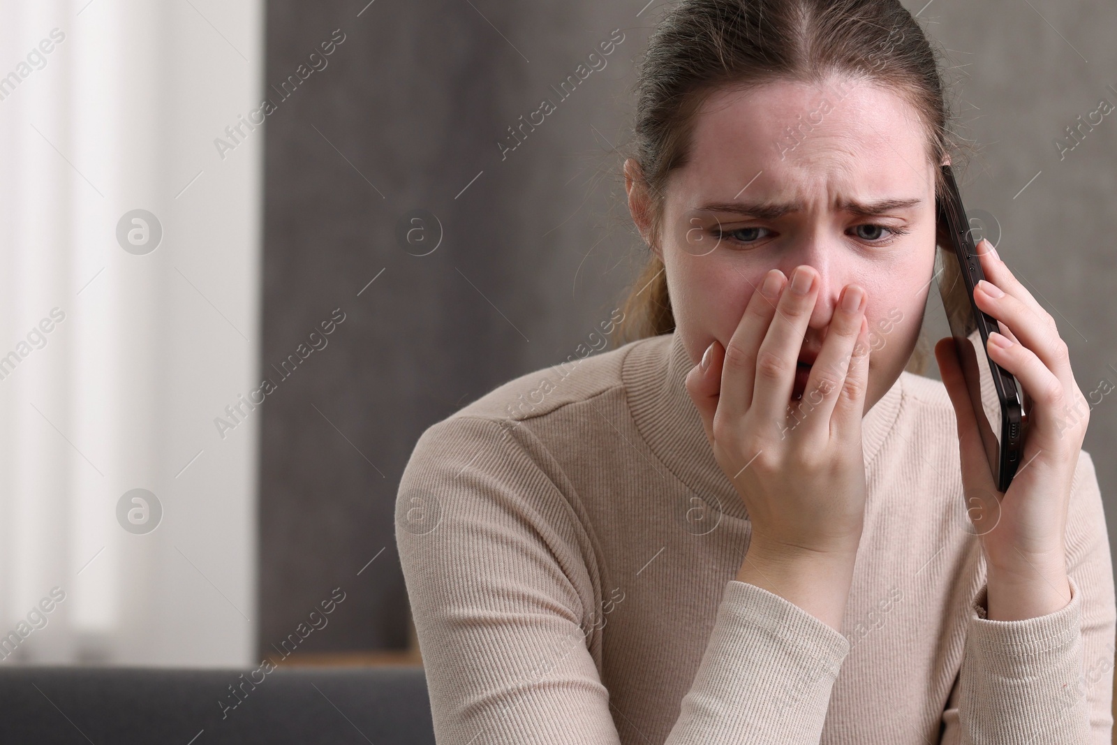 Photo of Stressed woman calling hotline for mental health help at home. Space for text