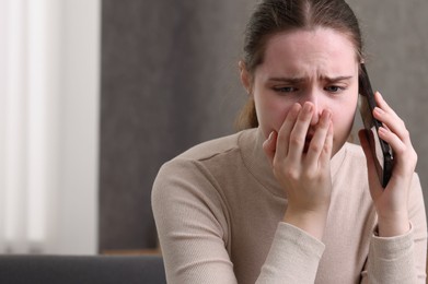 Photo of Stressed woman calling hotline for mental health help at home. Space for text