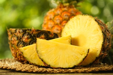 Fresh ripe pineapples on wooden table against blurred background, closeup