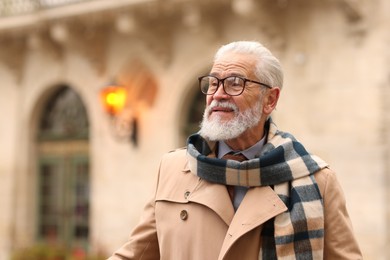 Photo of Stylish bearded senior man on city street. Space for text