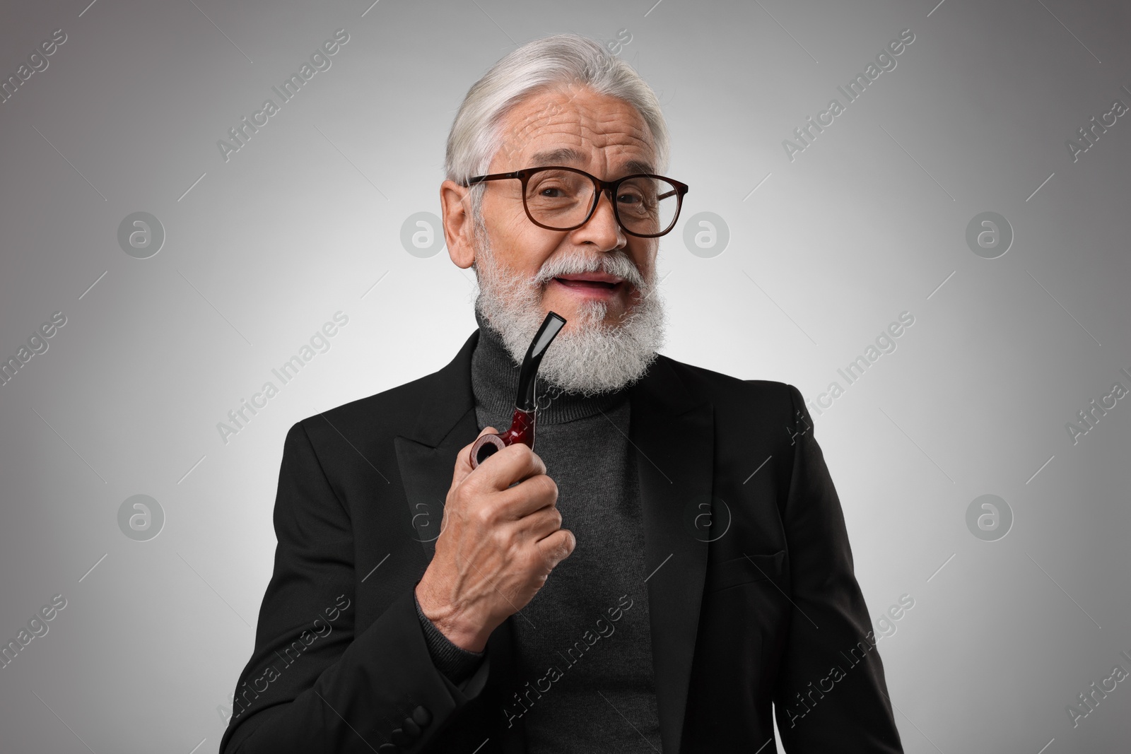 Photo of Senior man with tobacco pipe on light grey background