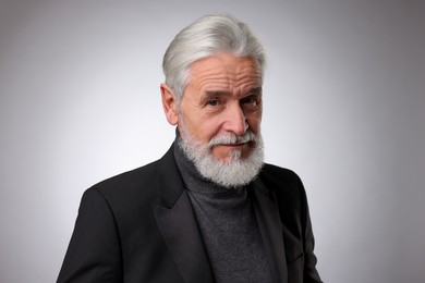 Photo of Portrait of confident senior man with silver beard on light grey background