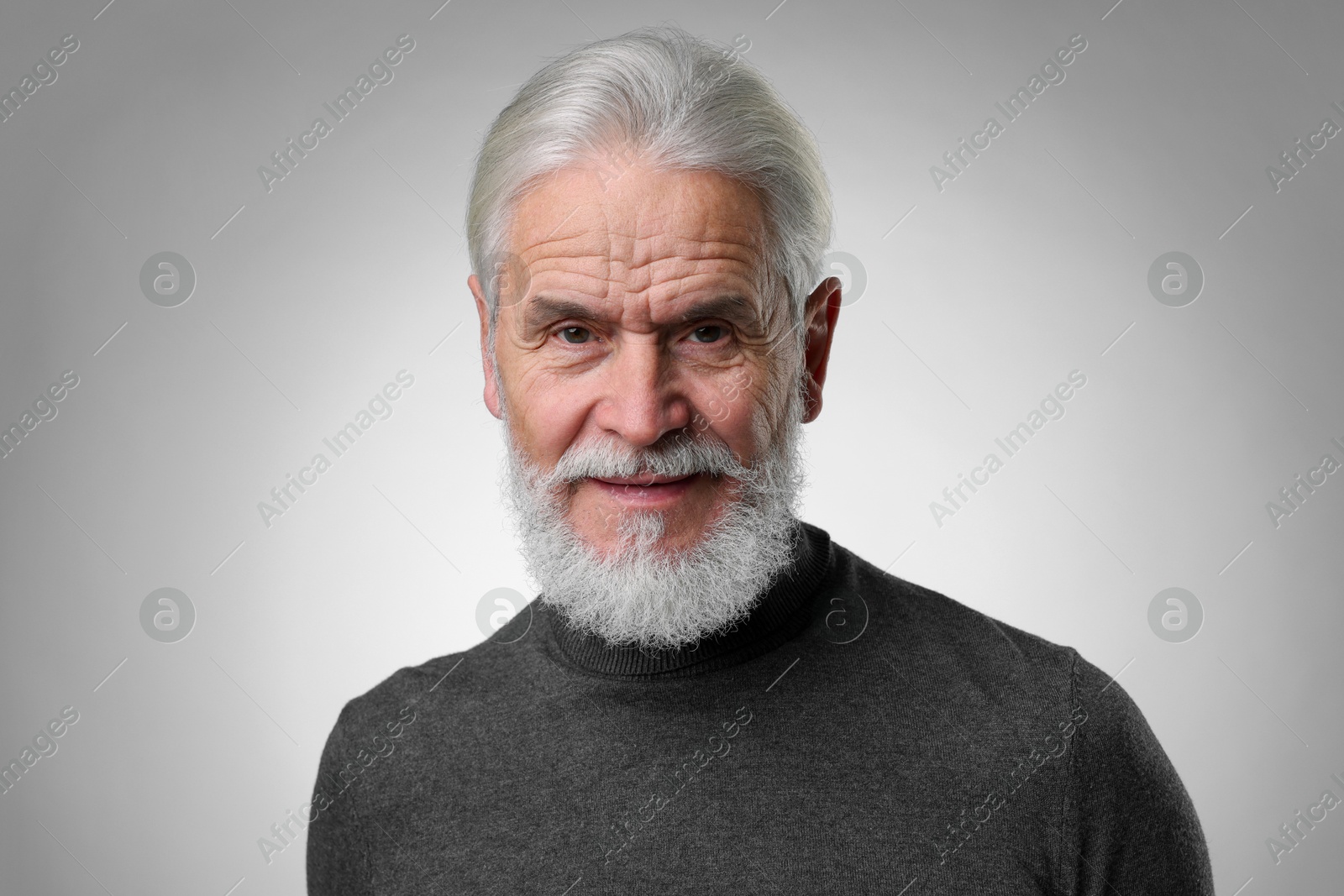 Photo of Portrait of confident senior man with silver beard on light grey background