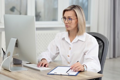 Photo of Technician making digital engineering drawing on computer at desk in office