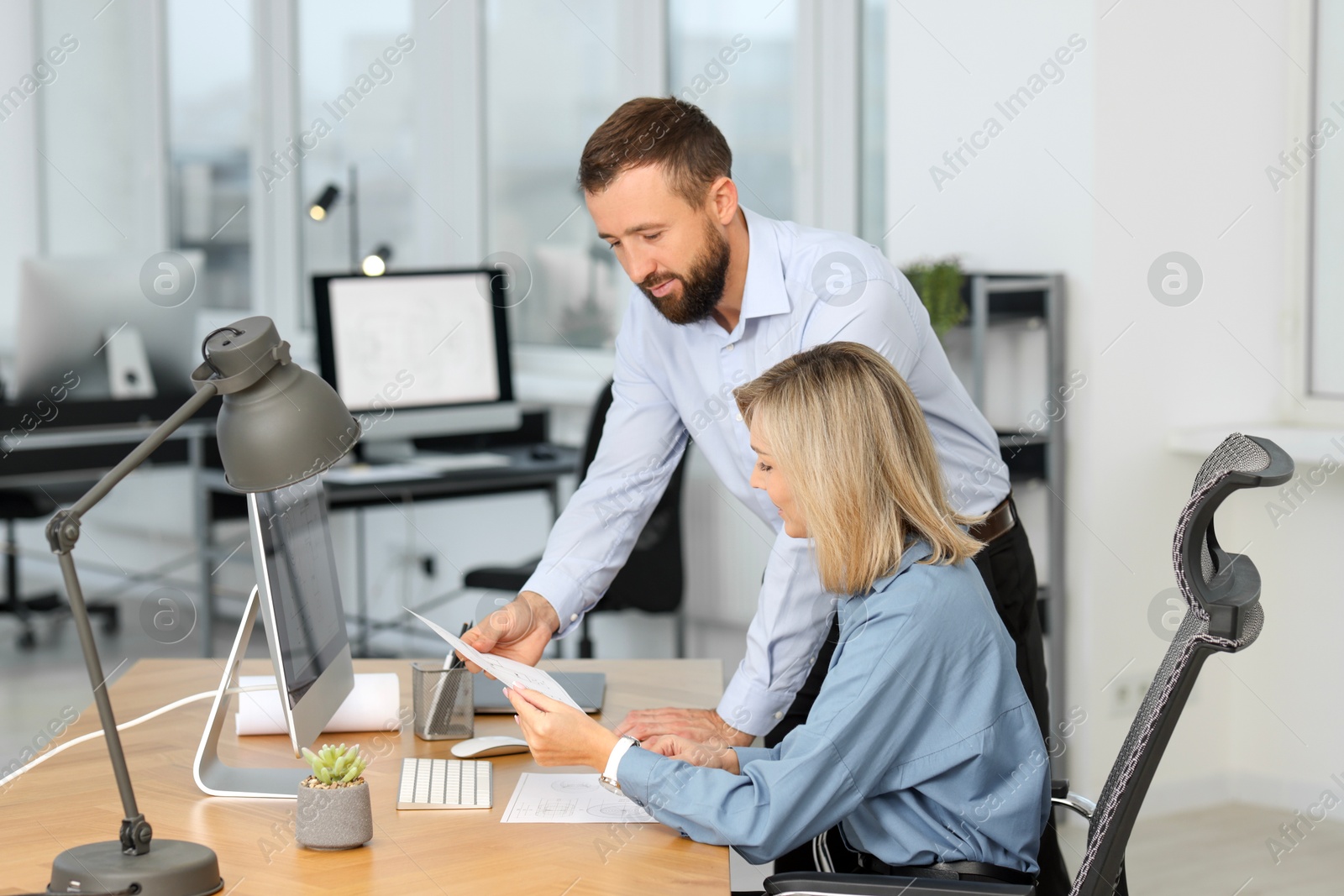 Photo of Technicians making digital engineering drawing on computer at desk in office