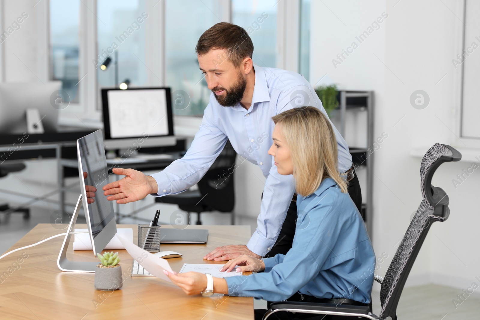 Photo of Technicians making digital engineering drawing on computer at desk in office