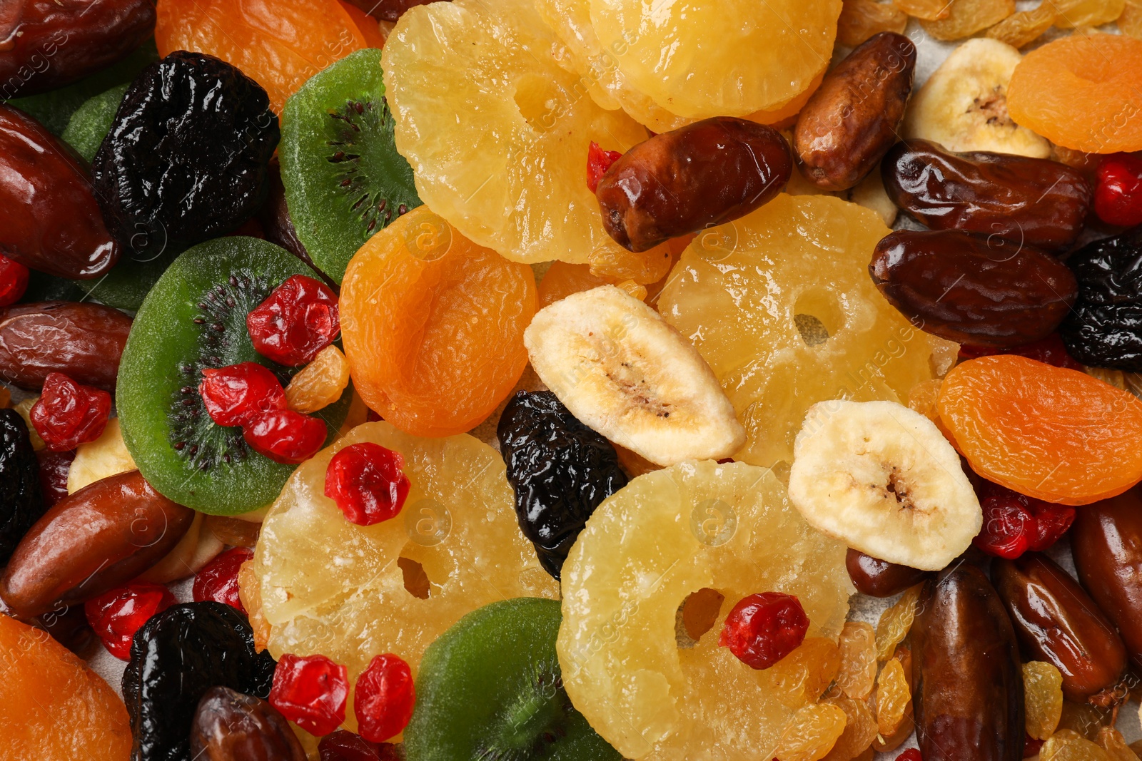 Photo of Mix of different dried fruits as background, top view