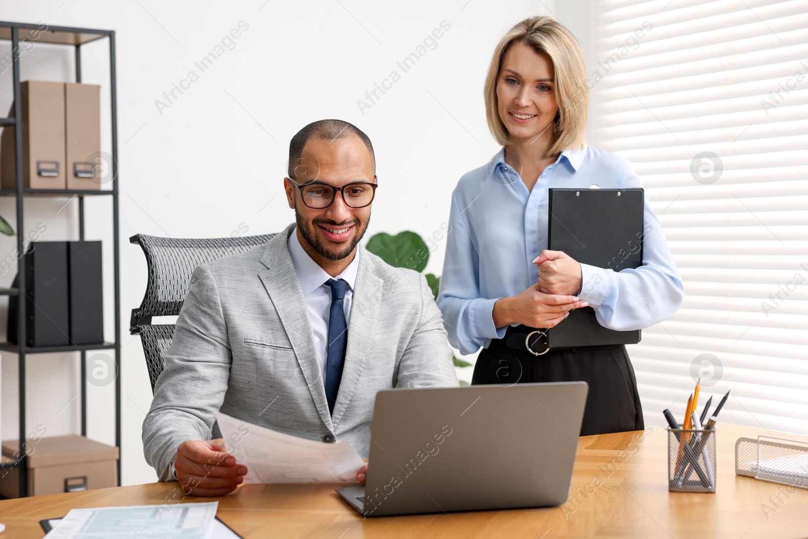 Photo of Coworkers with laptop working together in office