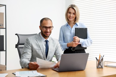 Photo of Coworkers with laptop working together in office