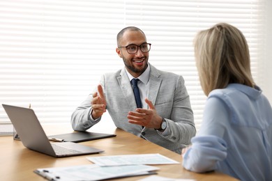 Photo of Coworkers working together at table in office