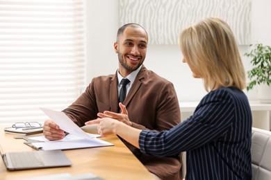 Photo of Coworkers working together at table in office