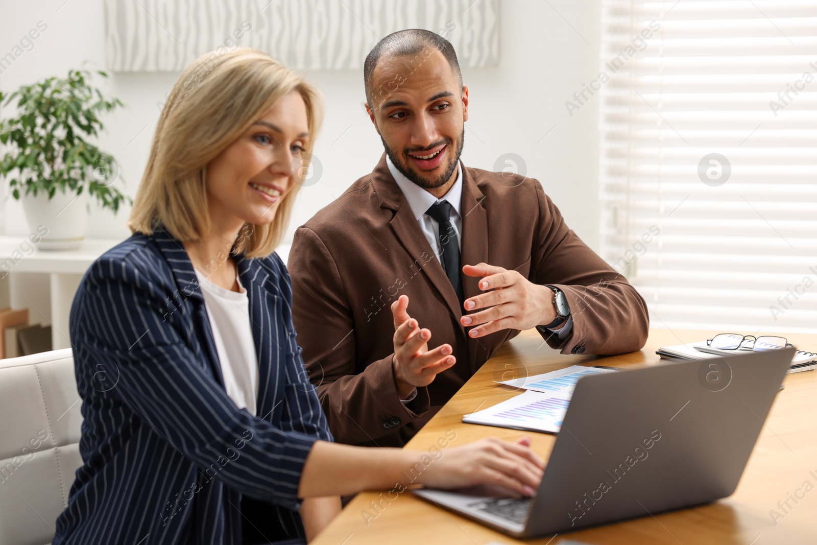 Photo of Coworkers with laptop working together in office