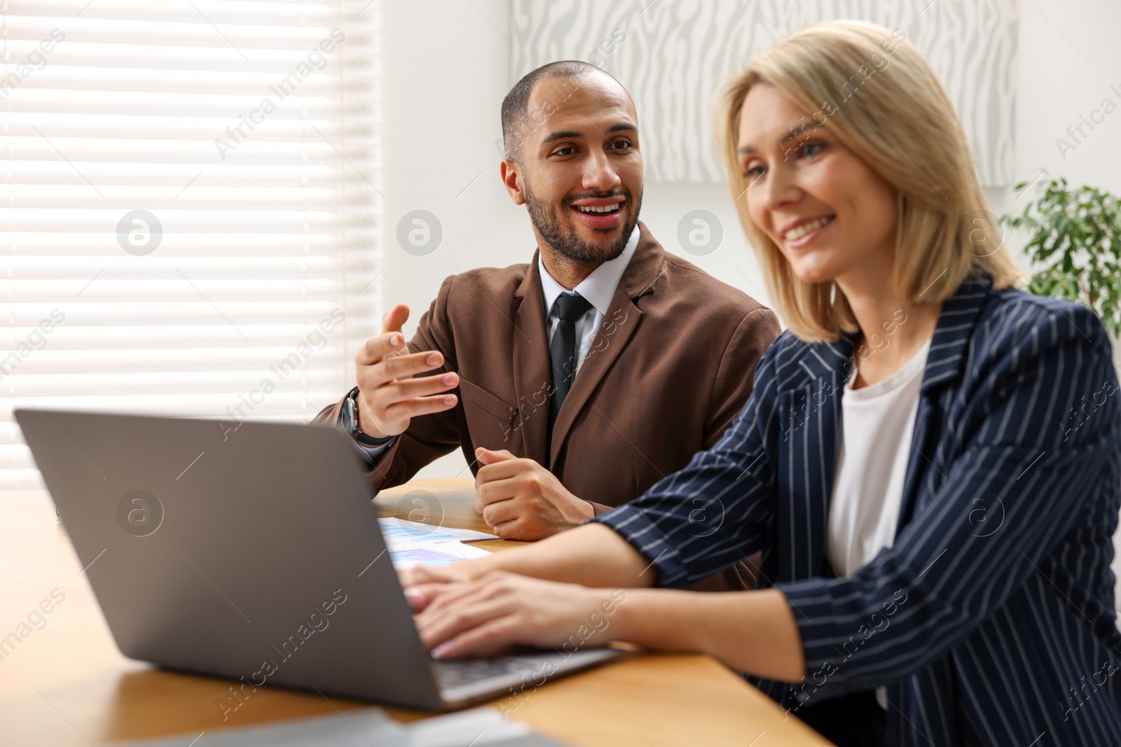 Photo of Coworkers with laptop working together in office